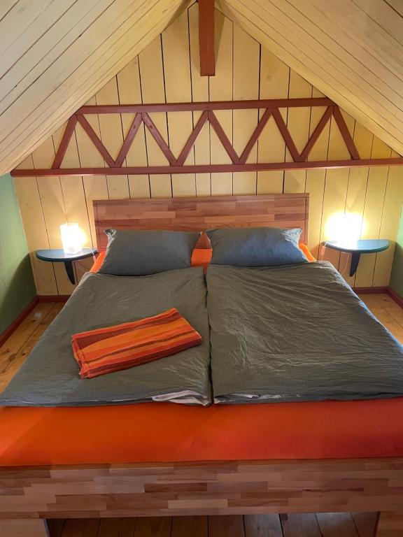 a bed in a room with two lamps on tables at Badehaus Villa Fiedrichs in Ilmenau