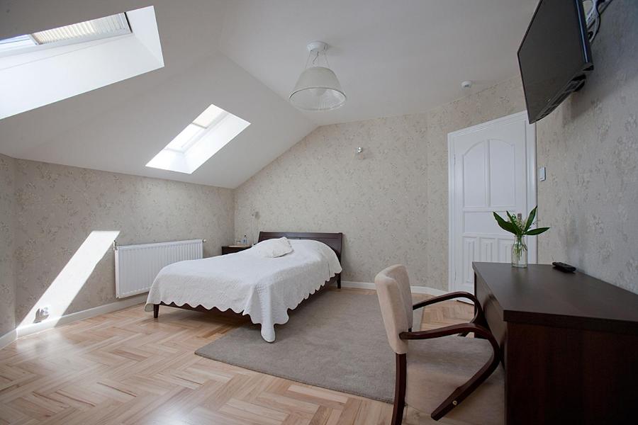 sypialnia z białym łóżkiem, biurkiem i stołem w obiekcie Impresja Restauracja Hotel w mieście Zambrów