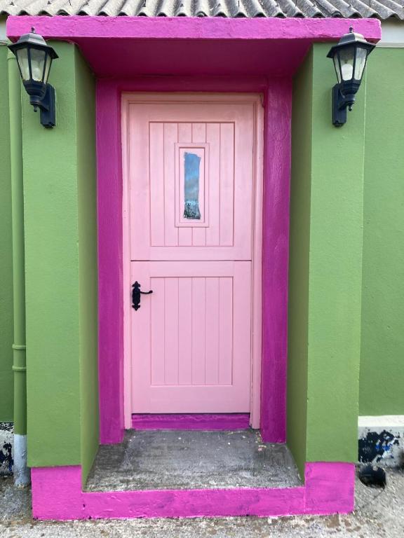 a pink door on the side of a house at Lime cottage in Kilrush