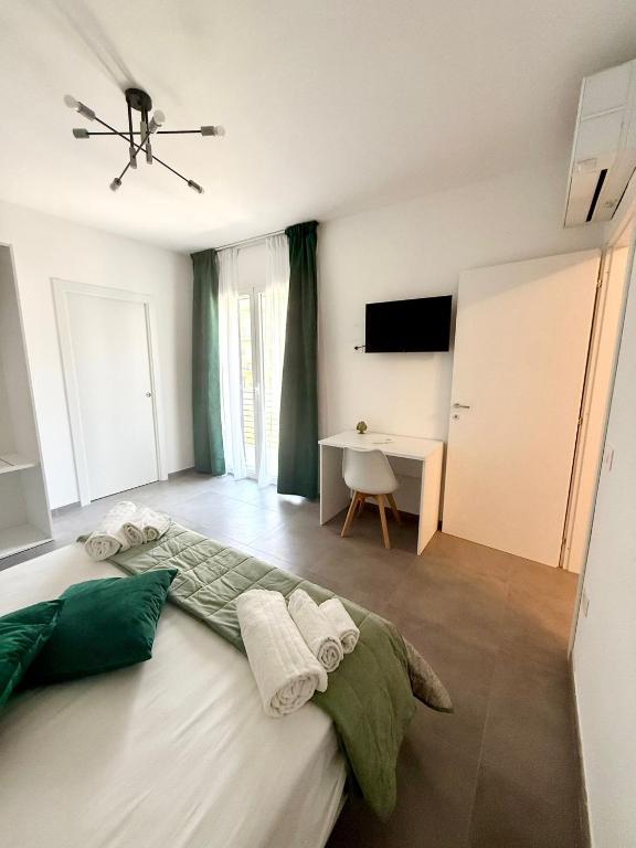 a bedroom with a bed and a desk in it at Novea Apartments - Comodi Appartamenti con Parcheggio & Wi-Fi vicino Taormina in Taormina