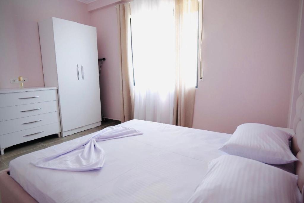 a bedroom with a white bed and a dresser at Aren Suite in Vlorë
