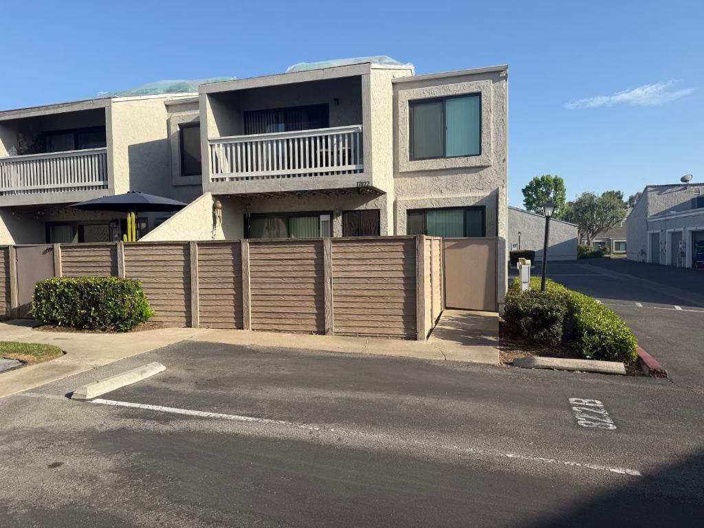 ein Haus mit einem Holzzaun vor einer Straße in der Unterkunft Two Bedroom Condo in Huntington Beach in Huntington Beach