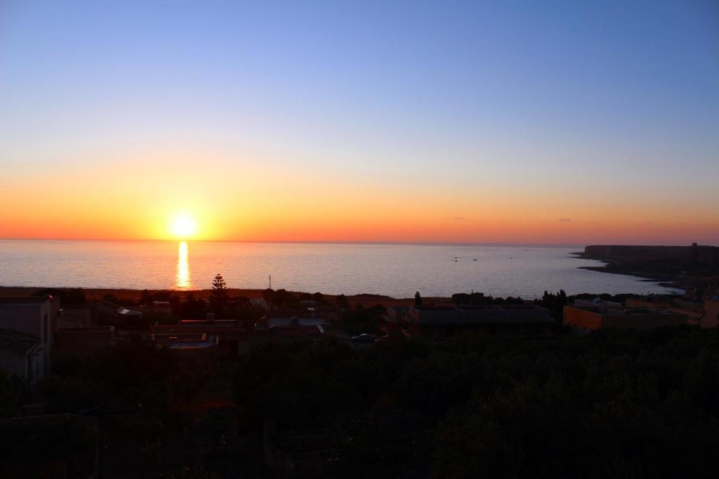 a sunset over the ocean with the sun setting at Appartamenti da Clarissa in Macari