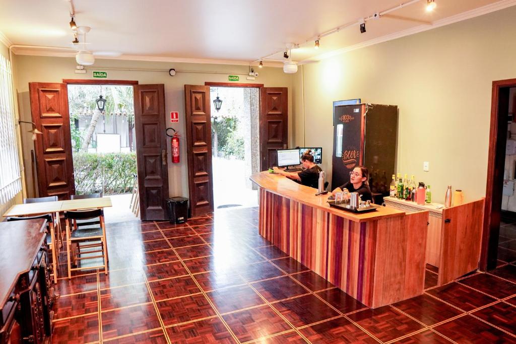 a bar with two people sitting at a counter at Local Hostel e Suites Belem in Belém