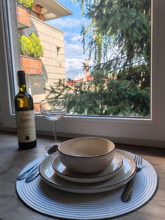 a table with a bowl and a wine glass and a window at Studio 23 in Banja Luka