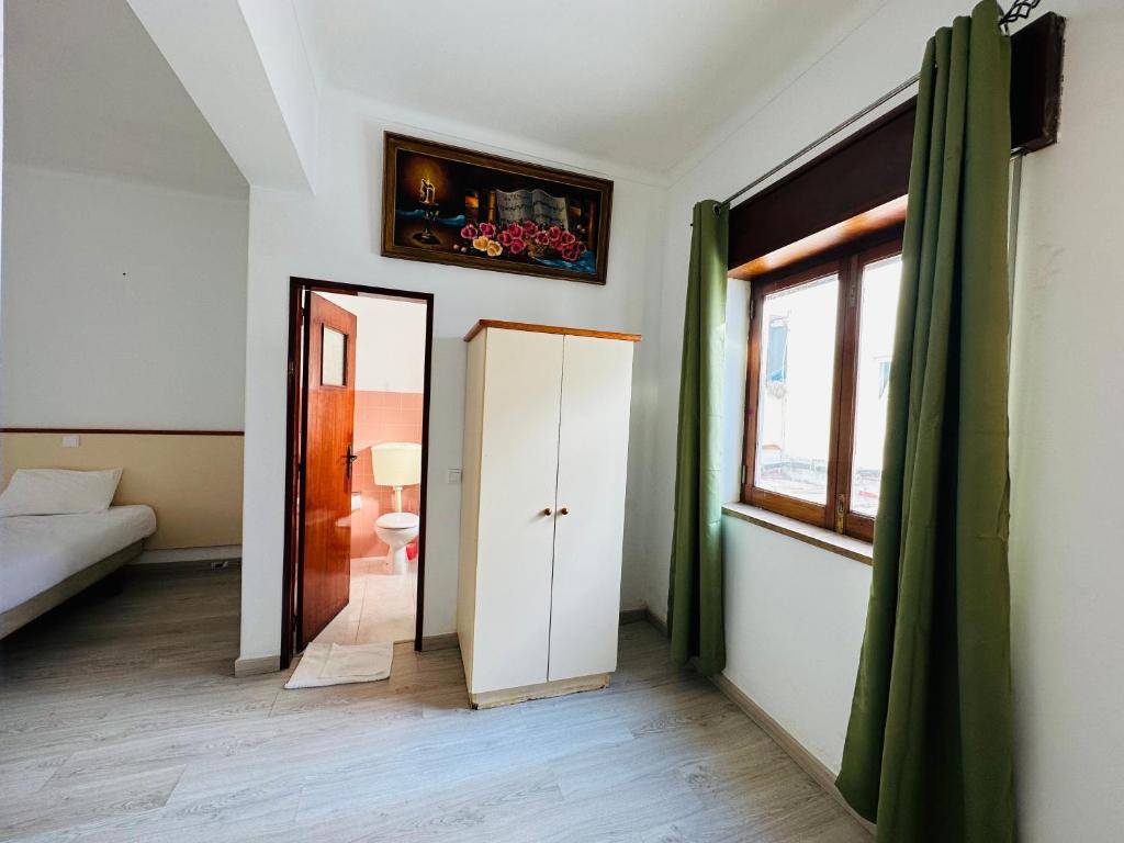 a room with a door and a bed and a window at Residencial Pimenta ,Portimao,Algarve in Portimão