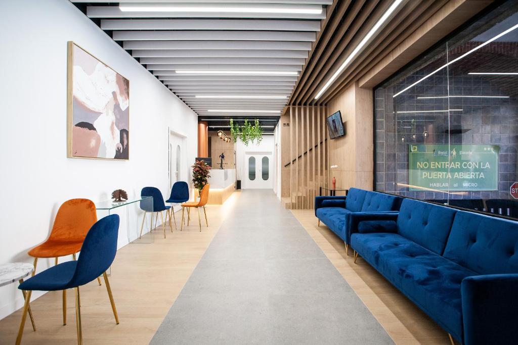a living room with blue couches and chairs at Pacoche Murcia in Murcia