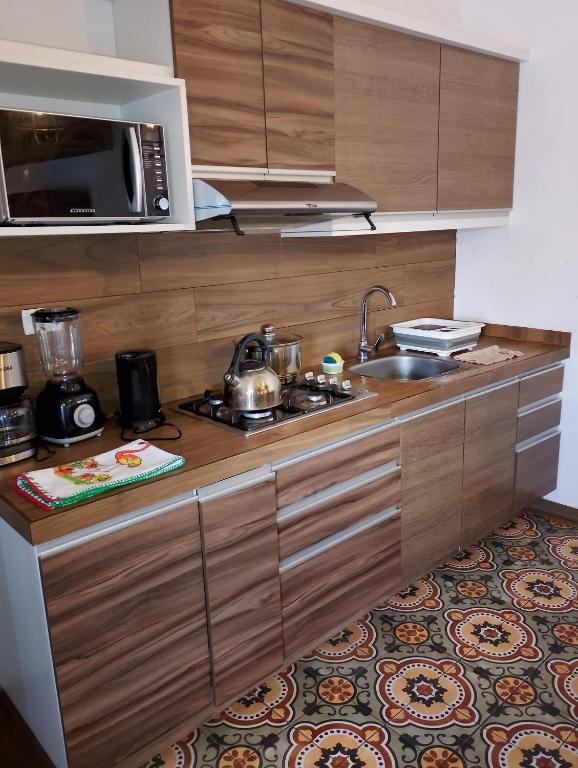 una cocina con fregadero y microondas en k'uychi Wasi, en Cusco