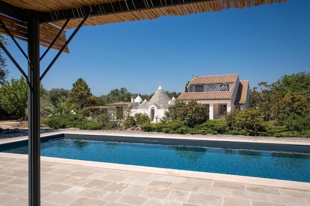 une image d'une piscine en face d'une maison dans l'établissement Villa Trullo Cantaluna - Esclusiva villa con trullo e piscina privata, à Ceglie Messapica