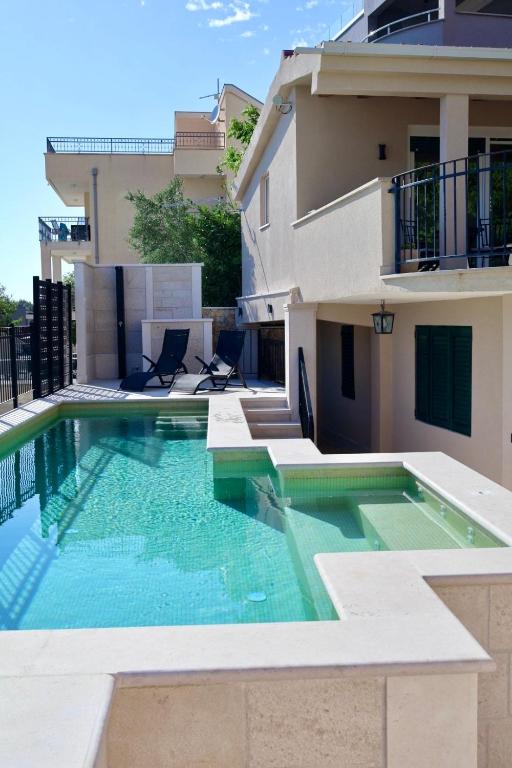 a swimming pool in front of a house at GV - Holiday home with MagnaPool in Makarska