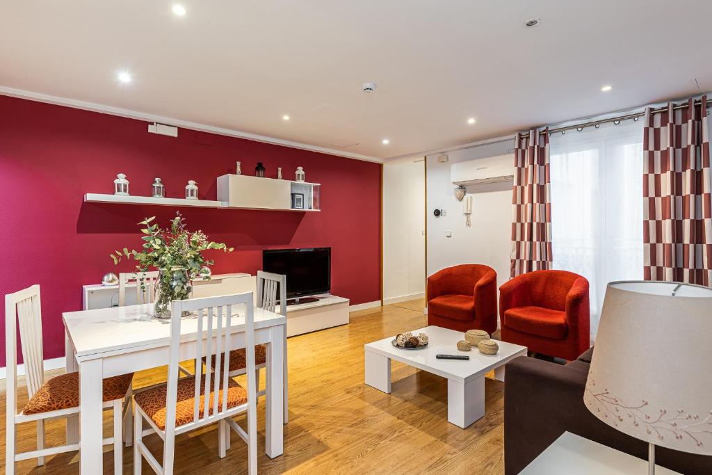 a living room with a red accent wall at Waou Apartamentos en Sol Confort 6 in Madrid