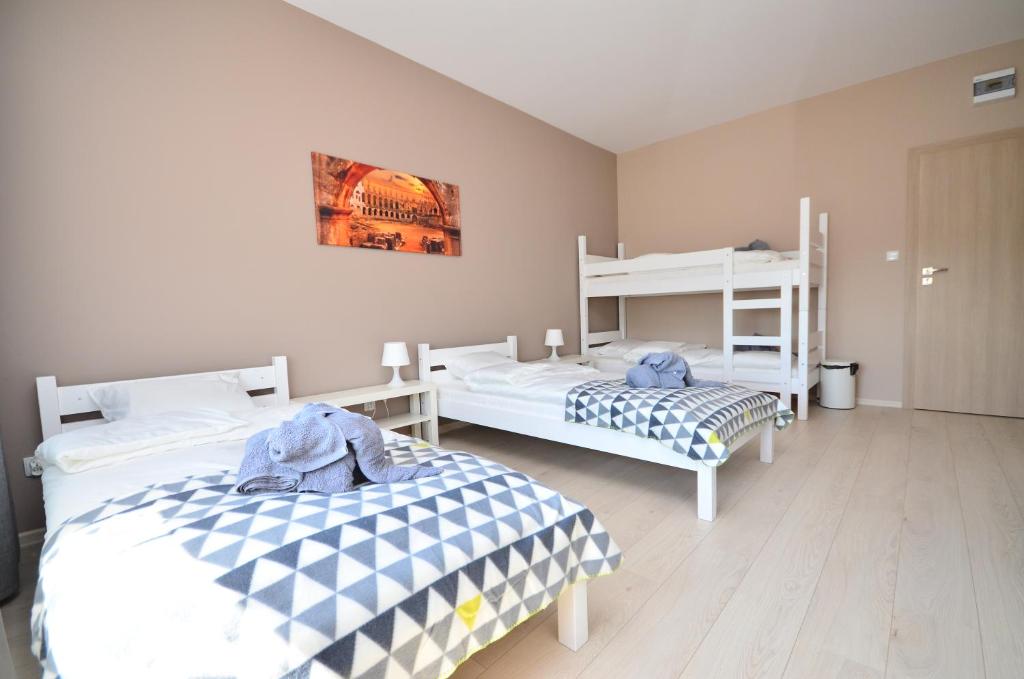 a bedroom with two beds and a bunk bed at G'HOSTEL in Deszczno