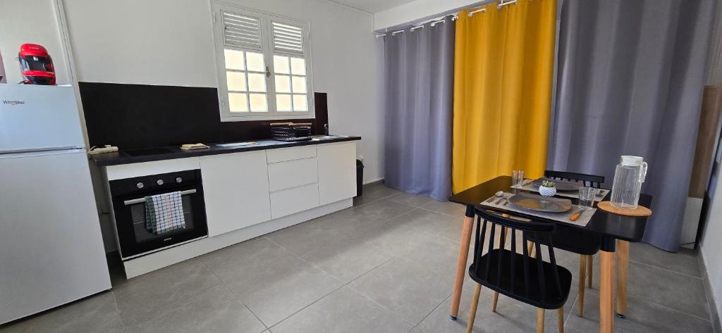 uma cozinha com uma mesa e uma geladeira em La Fleur Doré Studio em Le Vauclin