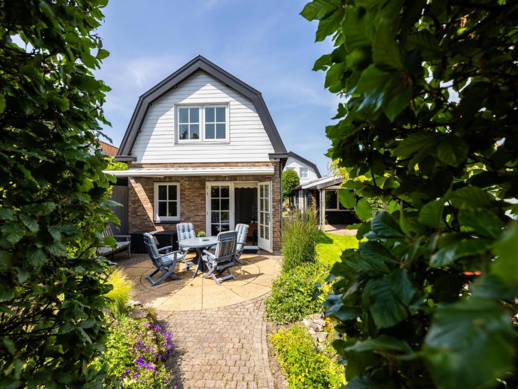 a house with a patio with a table and chairs at De Steeneik in Oostdorp