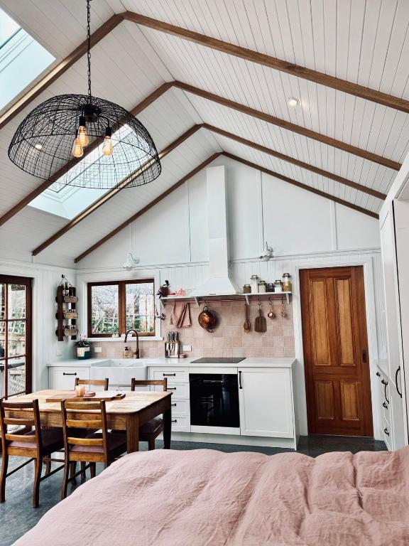 a kitchen with a table and a dining room at The Orangerie in Hobart