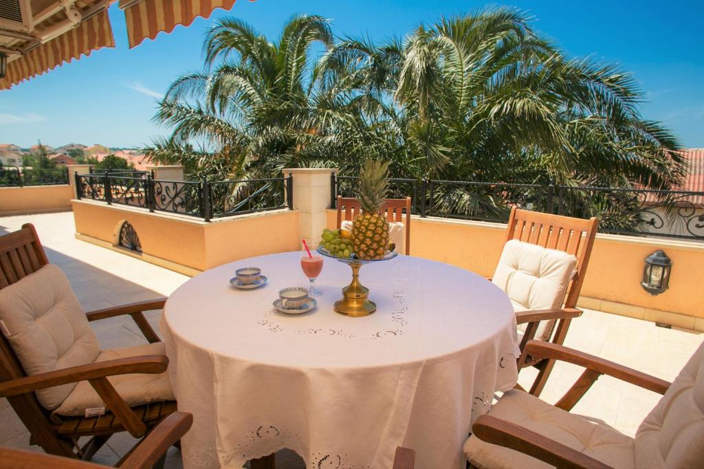 a table with a white table cloth on a balcony at Apartments Tomulić in Novalja