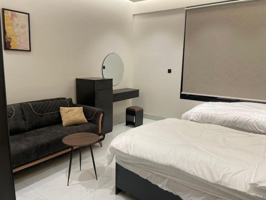 een slaapkamer met een bed, een stoel en een schoolbord bij أركان نموذجية in Riyad