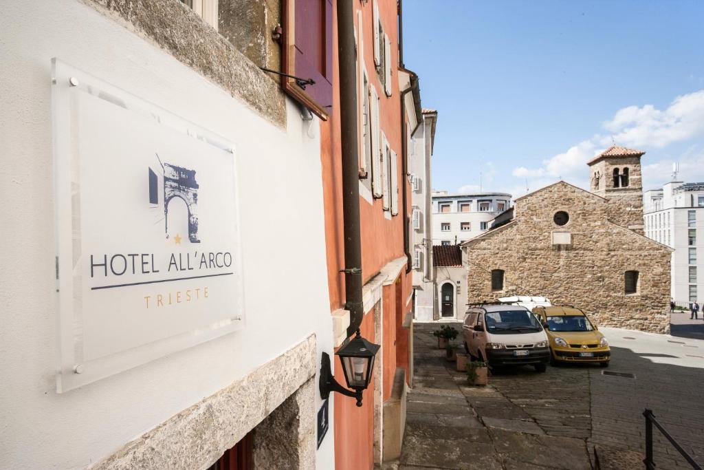 a sign on the side of a building on a street at Hotel All'Arco in Trieste