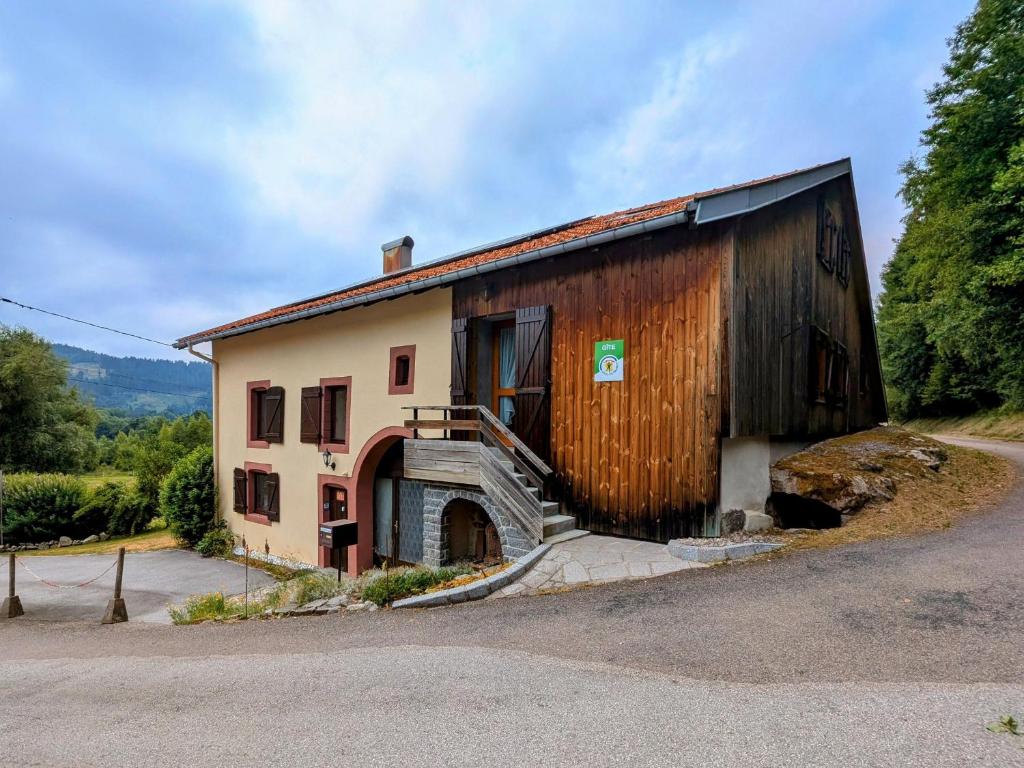 un bâtiment avec un escalier sur le côté dans l'établissement Gîte Authentique en Ferme Vosgienne, Nature et Confort près de Gérardmer - FR-1-589-211, à Liézey
