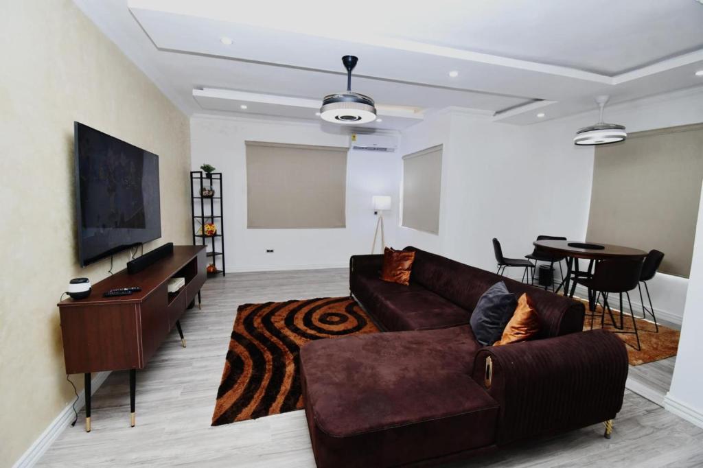 una sala de estar con un sofá y una mesa en Chanan Court Apartment, en Accra