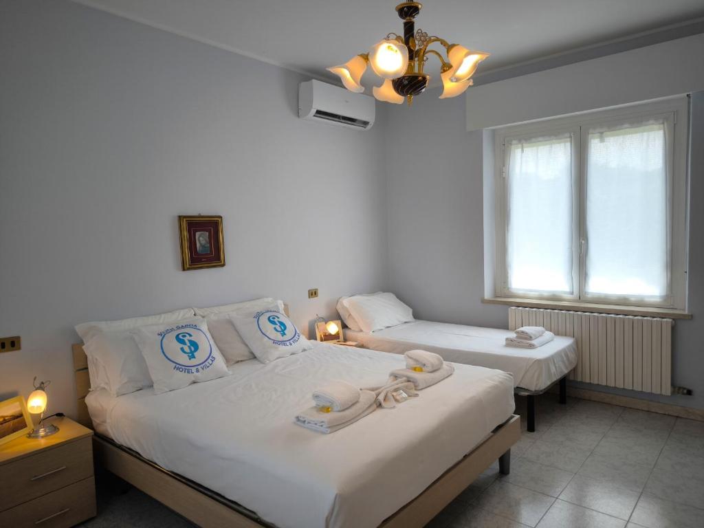 a bedroom with two beds and a chandelier at SG Family - Villa Secolo in Peschiera del Garda