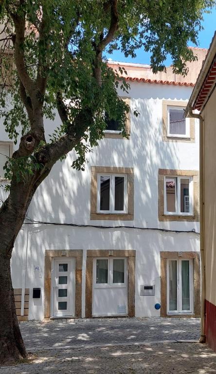 a white building with a tree in front of it at Casa das Olarias in Castelo Branco