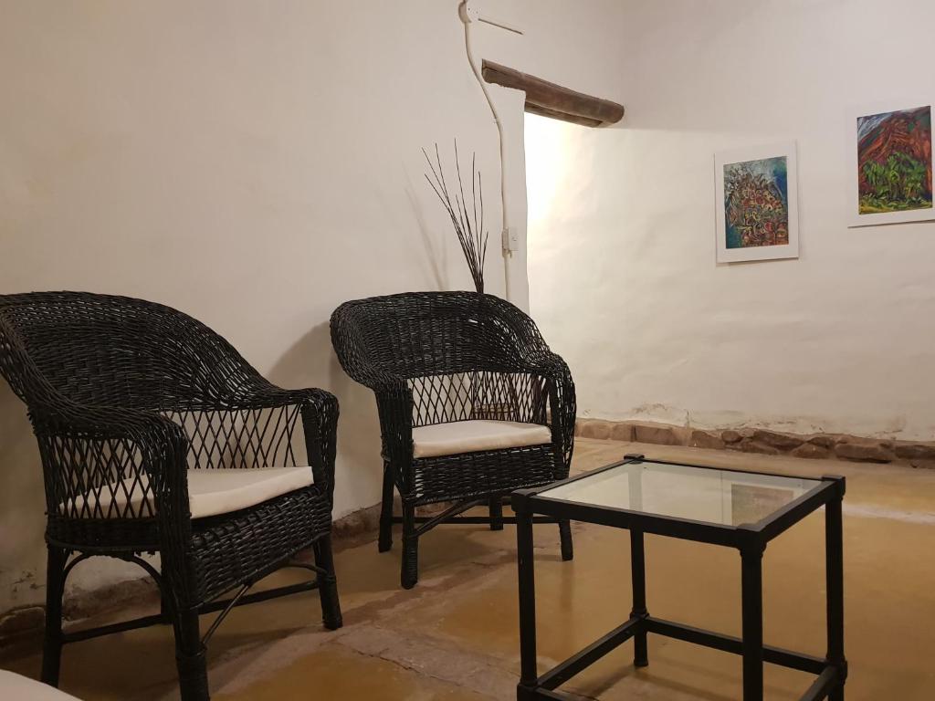 two chairs and a coffee table in a room at Casa en Tilcara - Espaciosa, equipada y lista para disfrutar in Tilcara