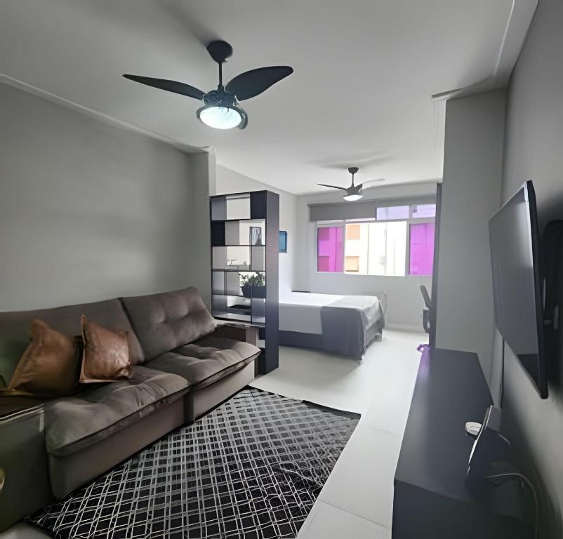 a living room with a couch and a bed at Lindo Apto Beira Mar - Ponta da Praia - Santos in Santos