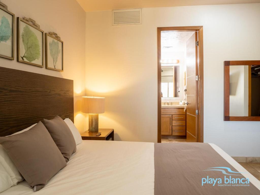 a bedroom with a bed and a bathroom with a mirror at Playa Blanca Premier Unit 504 in San Carlos