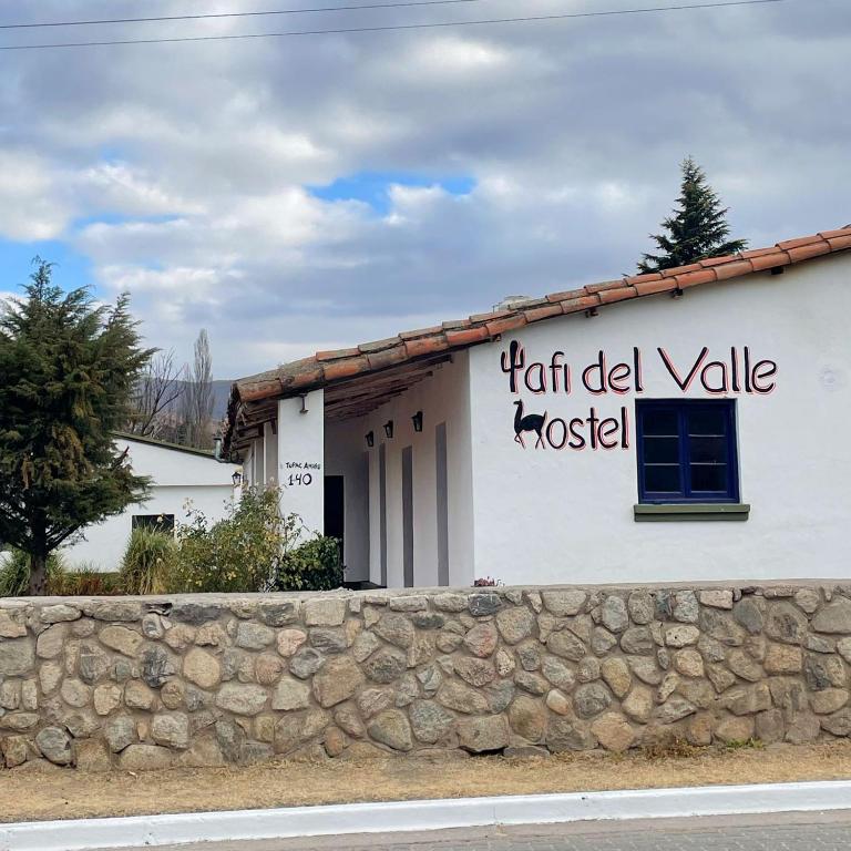 a white building with writing on the side of it at Tafi del Valle Hostel in Tafí del Valle