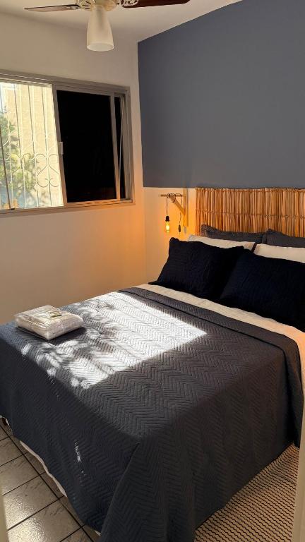 a large bed in a bedroom with a window at Descanso a poucos passos do mar! in Vila Velha