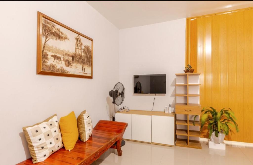 a living room with a wooden bench and a television at Rosie's Staycation in Trece Martires, Cavite in Quintana