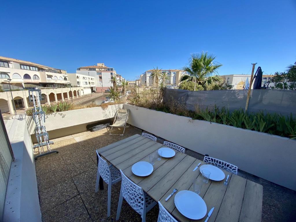 une table en bois assise au-dessus d'un balcon dans l'établissement Studio cabine climatisé, terrasse et parking proche plage - FR-1-338-604, à Sète
