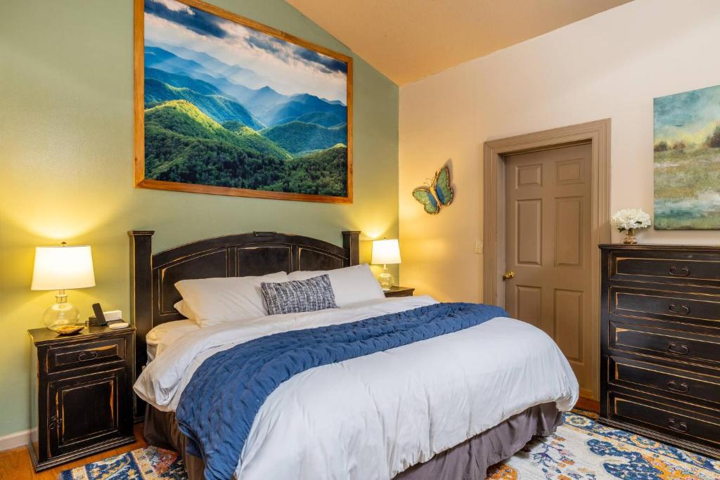 ein Schlafzimmer mit einem Bett und einem Gemälde an der Wand in der Unterkunft Super Cute! Hot Tub, Fully Stocked, Great Location in Glade