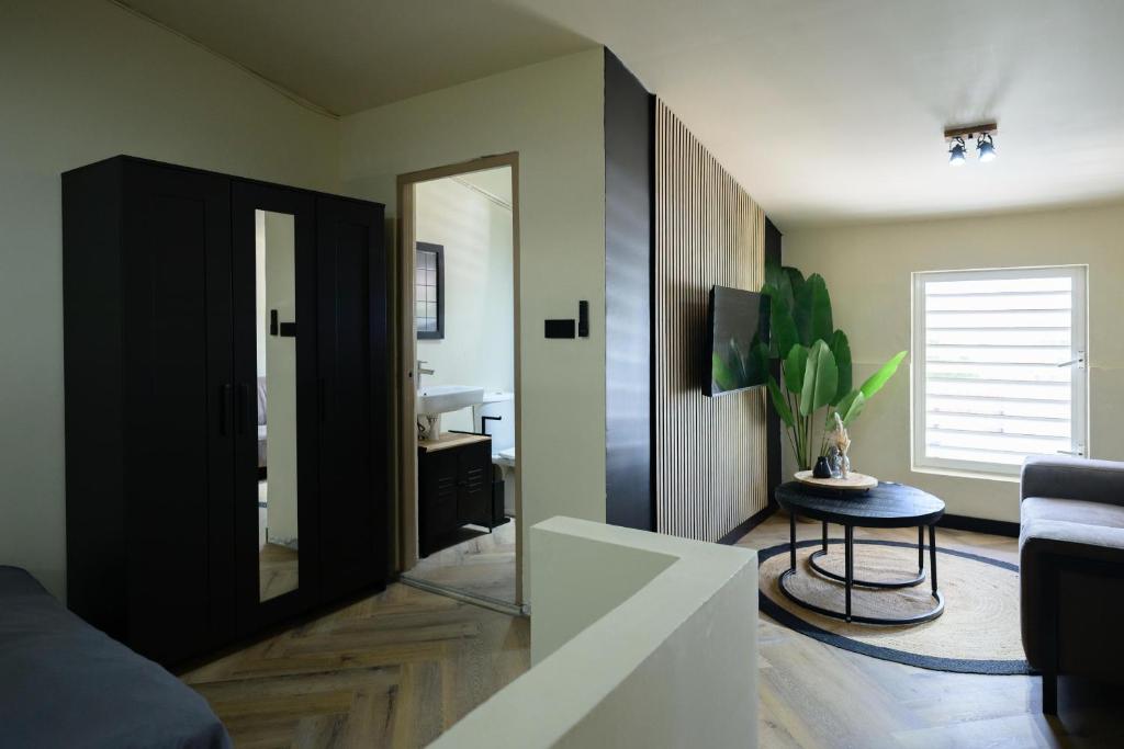 ein Wohnzimmer mit einem Spiegel und einem Waschbecken in der Unterkunft Aki Banda Suites in Willemstad