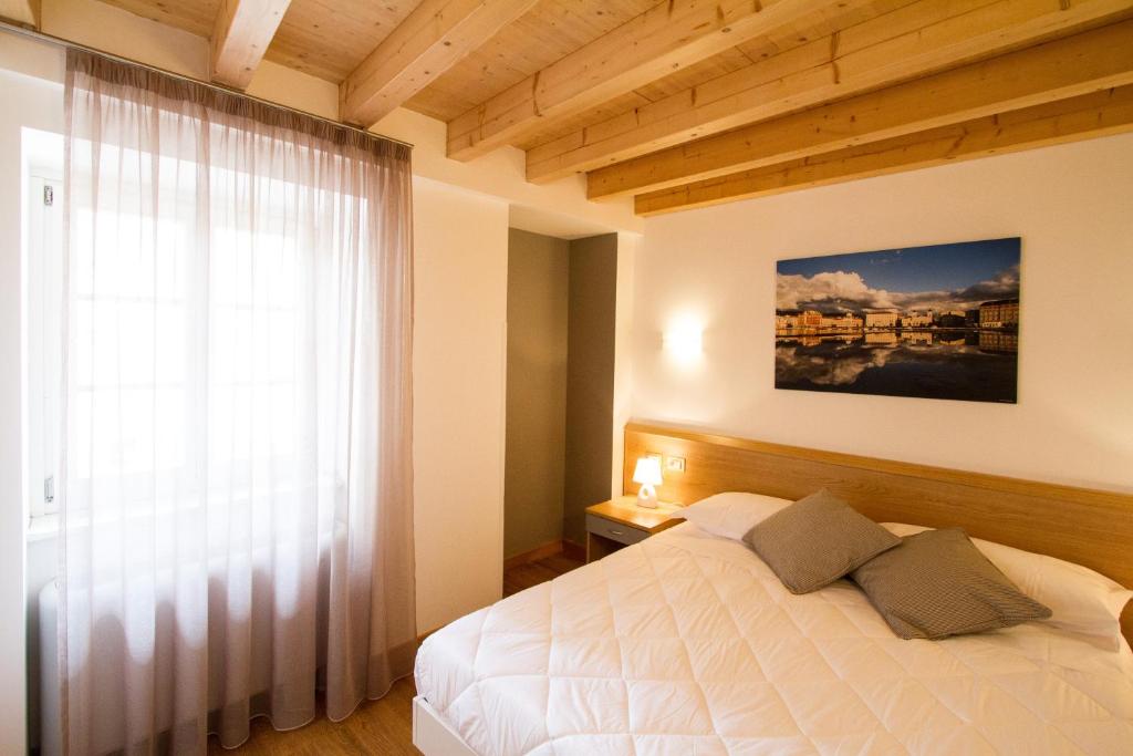 a bedroom with a white bed and a window at Hotel All'Arco in Trieste