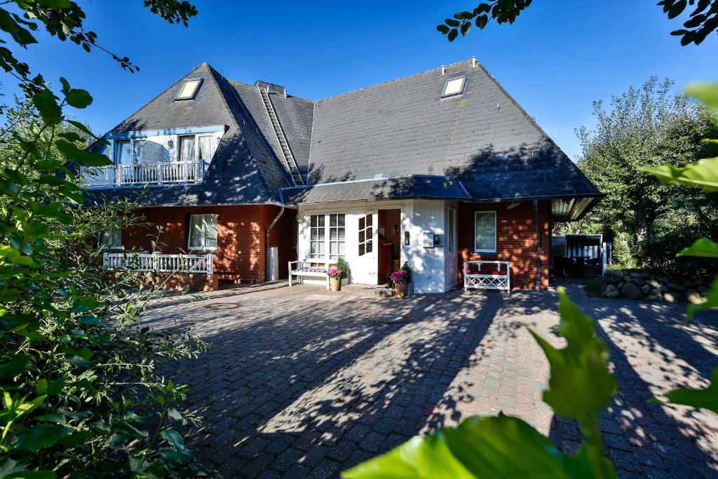 a house with a large driveway in front of it at Hotel am Südwäldchen in Westerland