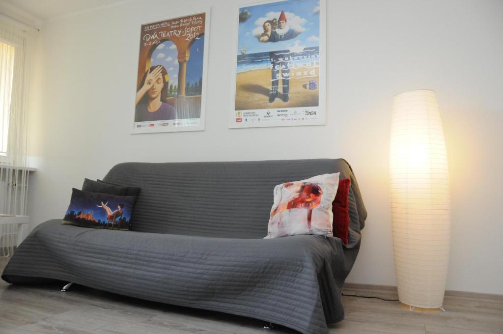a living room with a couch and posters on the wall at Mieszkanie 3 Maja in Sopot