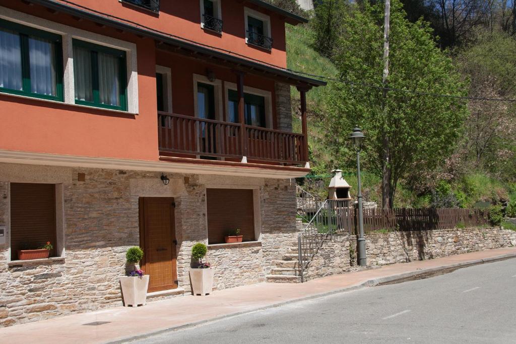 a building with potted plants in front of a street at Hostal El Recanto in Vega de Valcarce