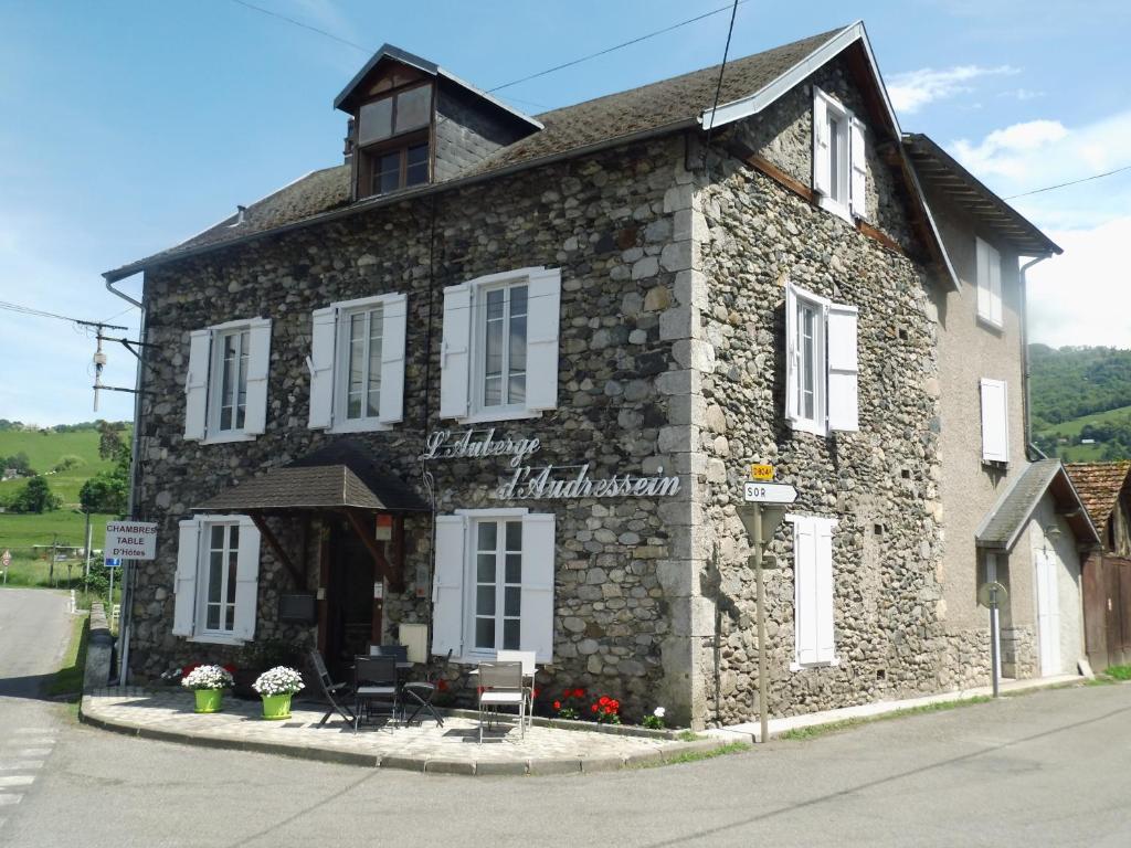 a stone building with a sign on the front of it at Auberge Audressein in Audressein