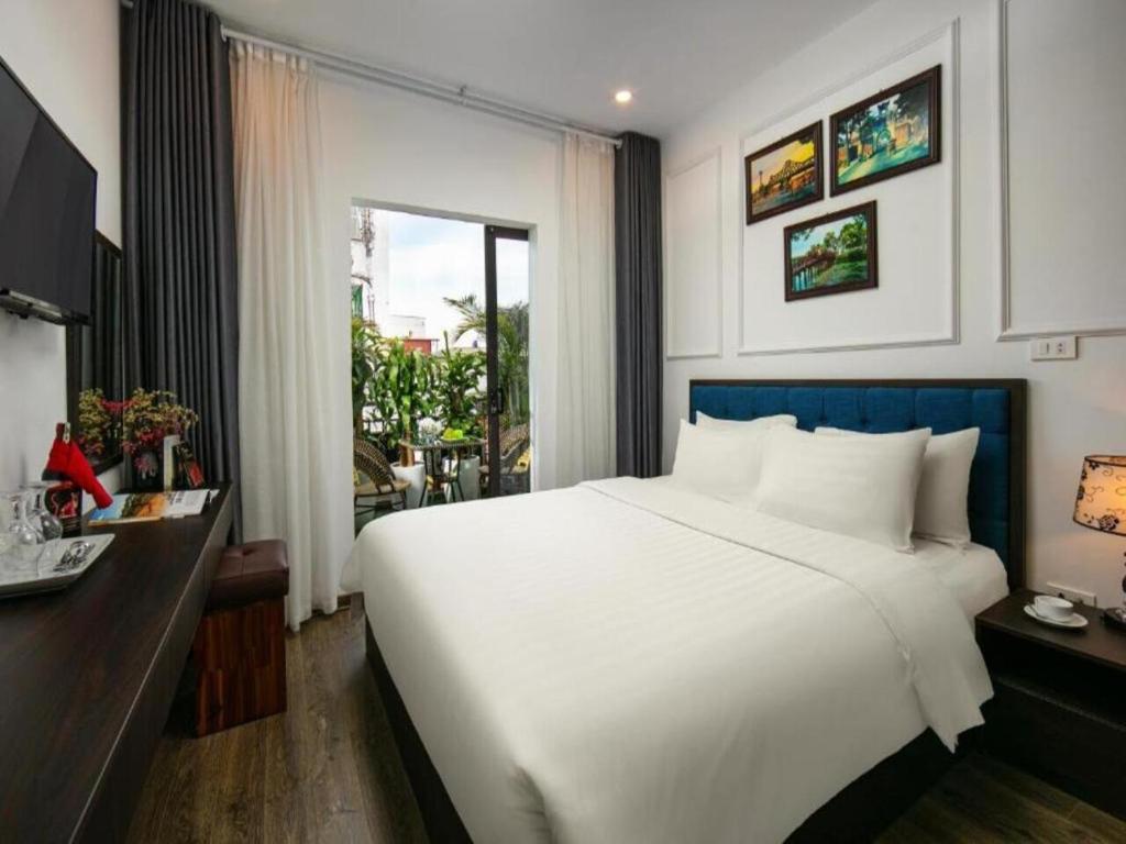 une chambre avec un grand lit blanc et une fenêtre dans l'établissement Dream Central Hotel & Spa - Hanoi Old Quarter, à Hanoï