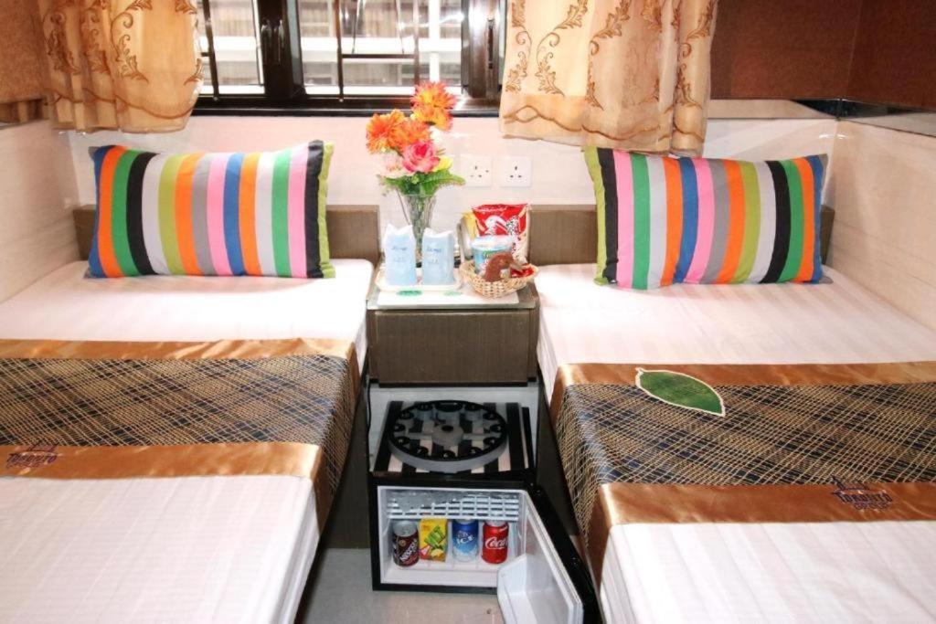 una camera con due letti e un vaso con fiori di Philippine Manila Motel 8F MIRADOR a Hong Kong