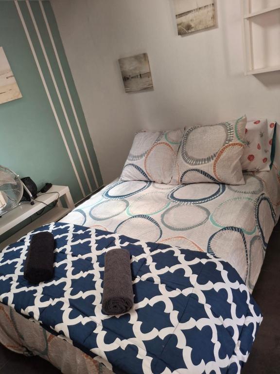une chambre avec un lit avec une couette bleue et blanche dans l'établissement STUDIO COSY climatisé 5 mn de la gare, à Sète