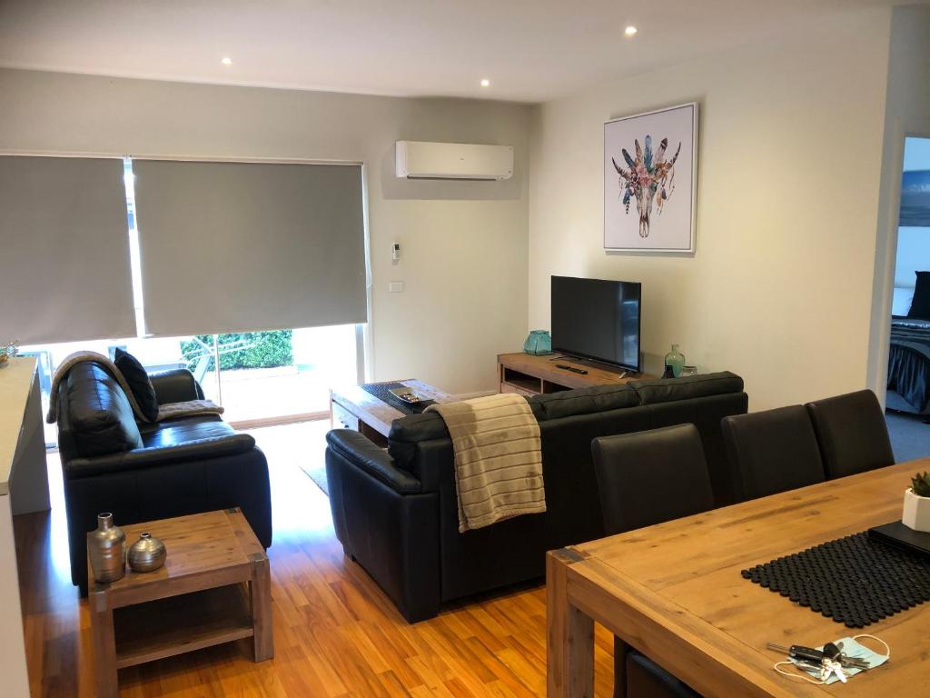 een woonkamer met 2 banken en een televisie bij Lbarza Stylish 3BR Central Serviced Apartment in Shepparton
