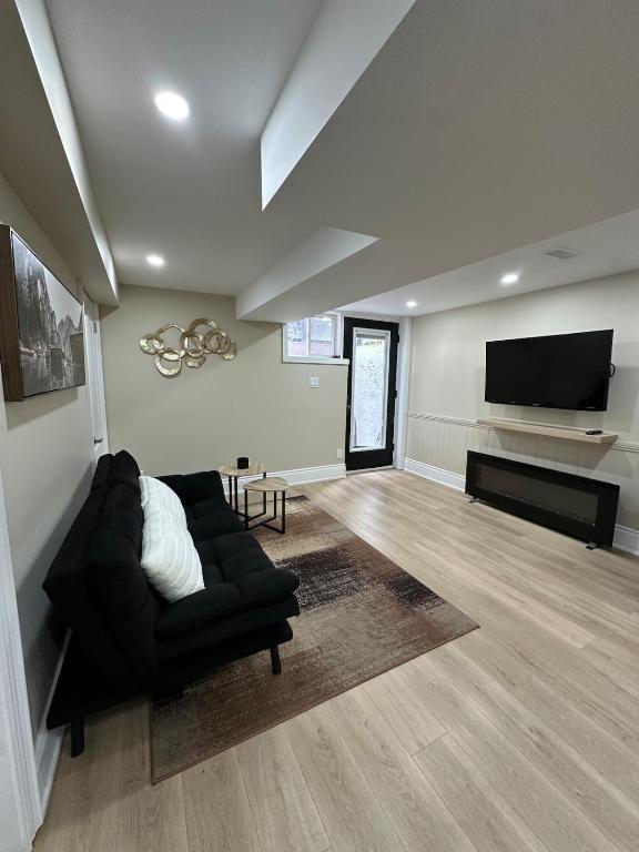 a living room with a couch and a flat screen tv at The Perfect Getaway in Orangeville