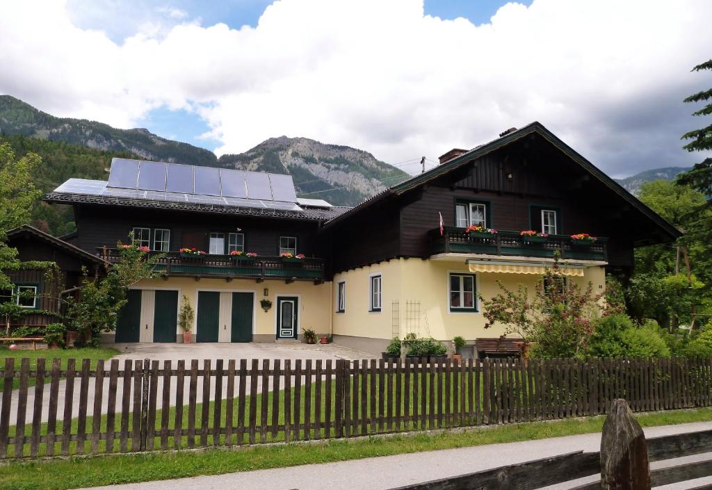 ein schwarzweißes Haus mit einem Sonnendach in der Unterkunft Ferienwohnung Schönauer in Haus im Ennstal