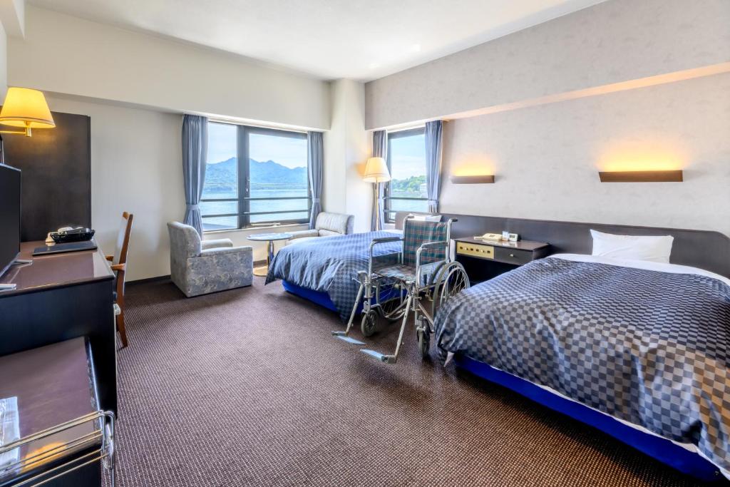 Postel nebo postele na pokoji v ubytování Miyajima Coral Hotel