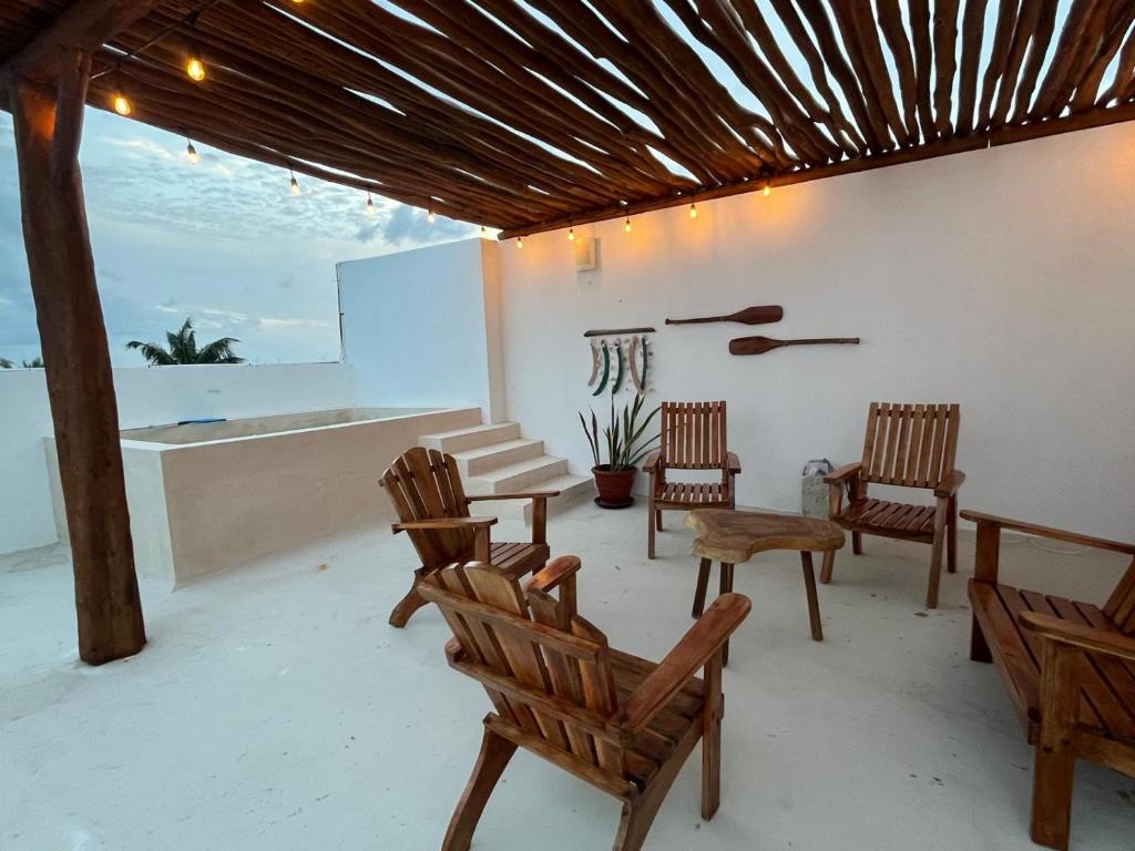 a room with chairs and a table and a counter at La Familia Chicxulub Beach Penthouse in Chicxulub