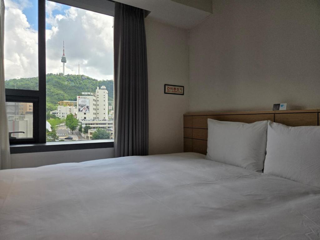 Postel nebo postele na pokoji v ubytování Henn na Hotel Seoul Myeongdong