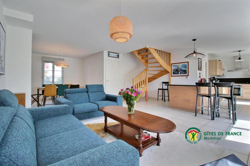 een woonkamer met blauwe banken en een tafel bij La vigerie in Carnac